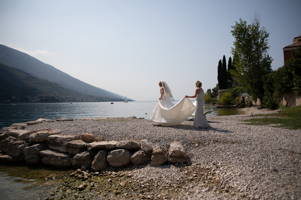 Bride and bridesmaid walking by the beach, Malcesine