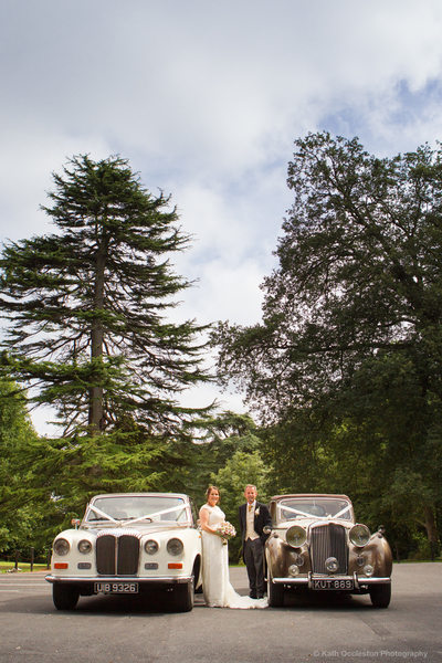 Couple with wedding cars at Bartle Hall