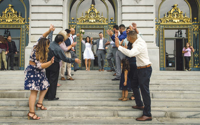 Fun newlywed couple leaving the San Francisco City Hall after their Wedding