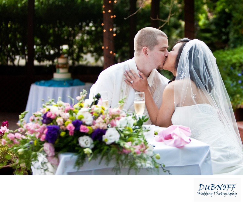 Newlyweds Kissing at the head table at Wildwood Acres