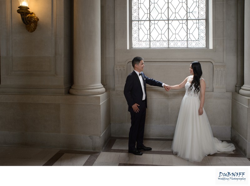 newlyweds holding hands at San Francisco city hall - Wedding photography image