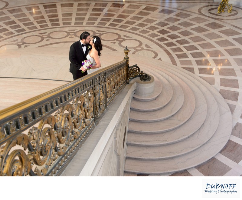 Newlyweds kissing on the Grand Staircase at SF City Hall
