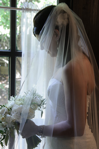 bride profile looking out the window with bouquet