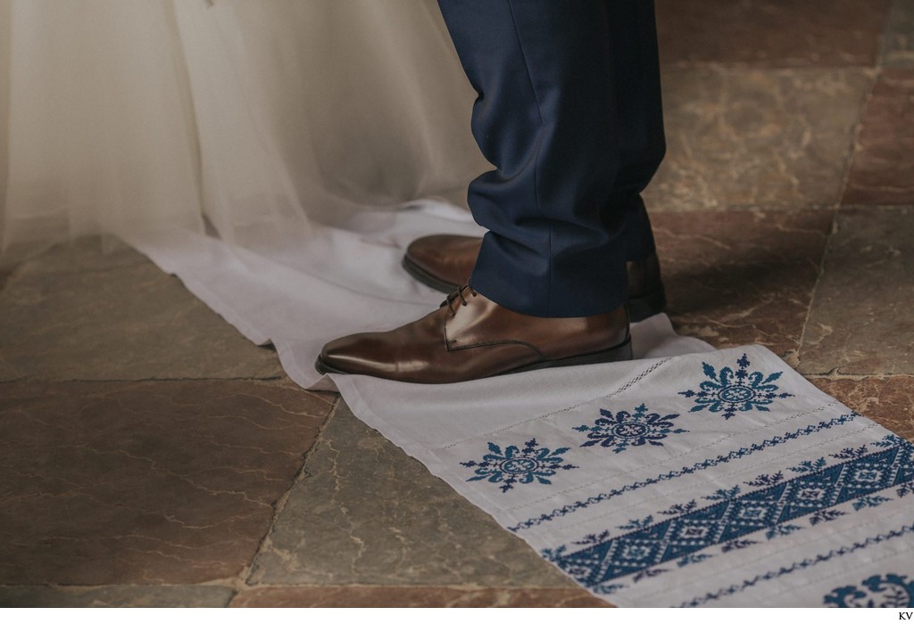 The groom stands on a cloth during his wedding day