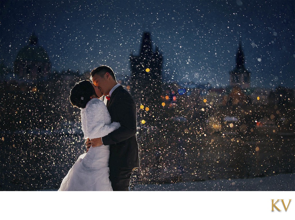 bride & groom kissing at night in a snowstorm in Prague