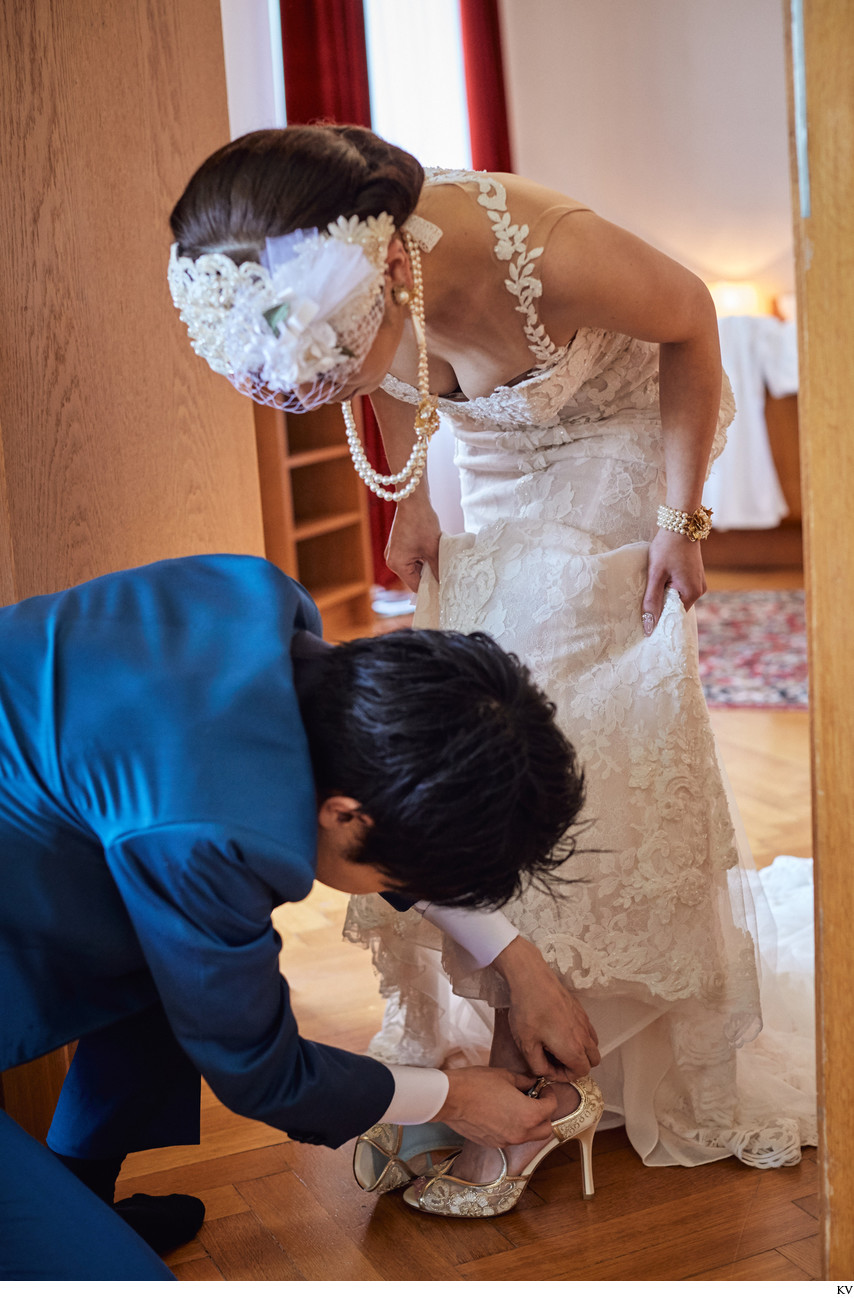 groom helps bride with shoes I Vila Bled Weddings