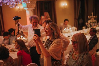 wedding guests take pictures during the party