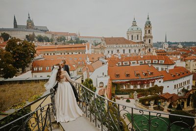 A bride & groom share a kiss atop the Vrtba Garden