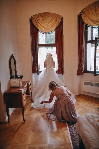 mother adjusts brides dress  Castle Hluboka wedding 