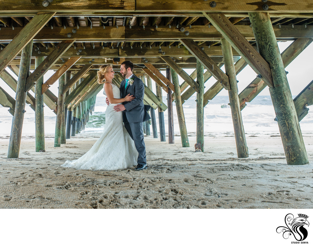 Groom and Bride under the pier at Wrightsville Beach