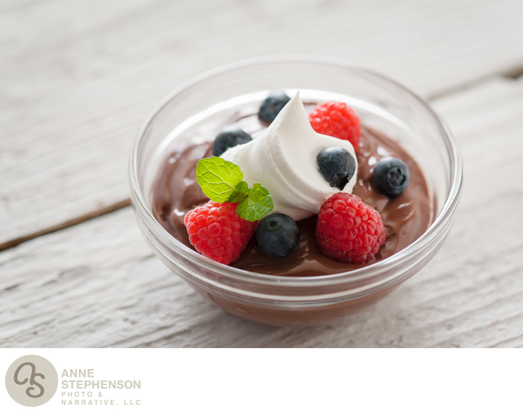 Chocolate pudding berry bowl with dollop of cream.