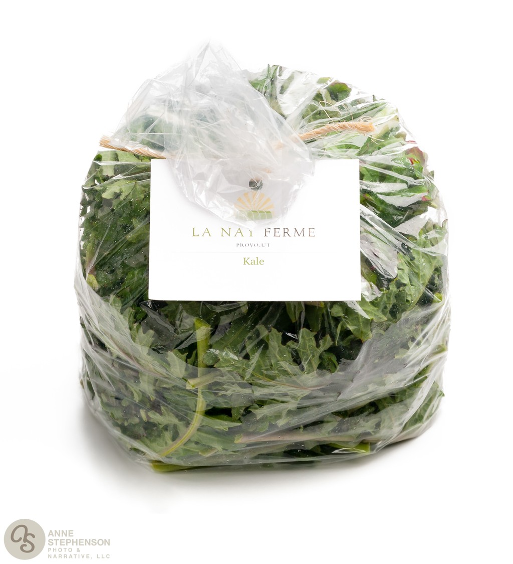 Closed and tied bag of purple kale on white