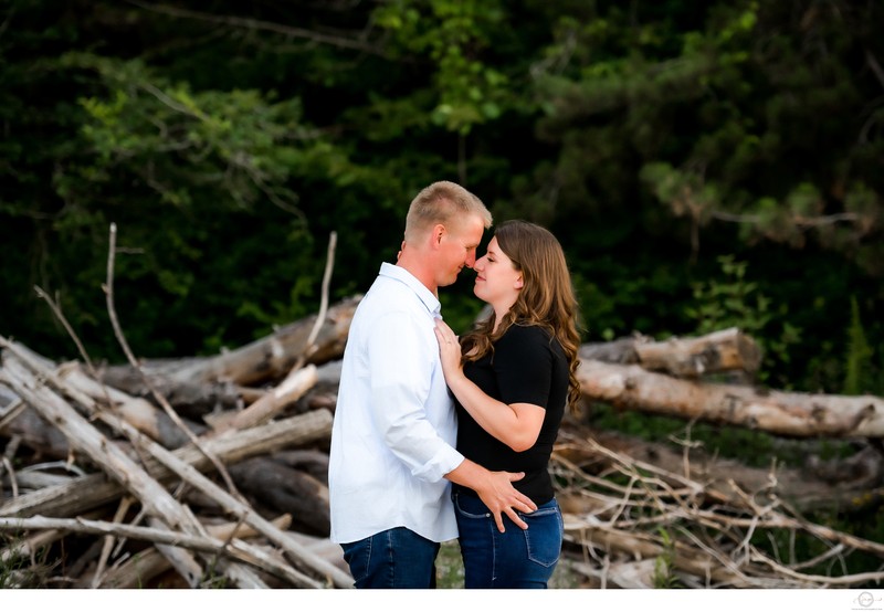 Engaged Couple Portraits in Front of Wood Pile