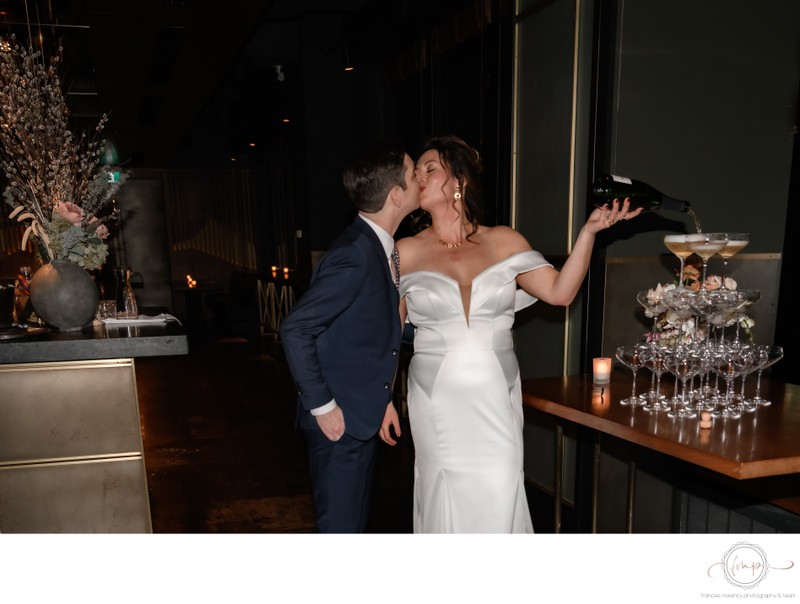 Bride Groom Kissing While Pouring Champagne Tower