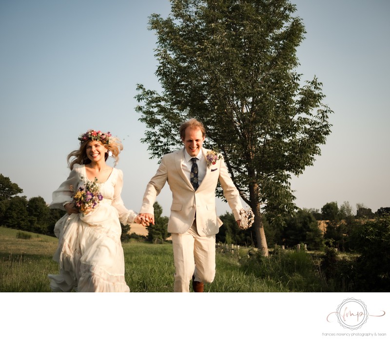 Boho Bride Running in Field with Groom in Cream Suit