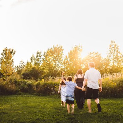 Family Walking in Golden Hour with Youngest Raising Arm