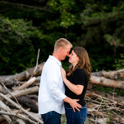 Engaged Couple Portraits in Front of Wood Pile