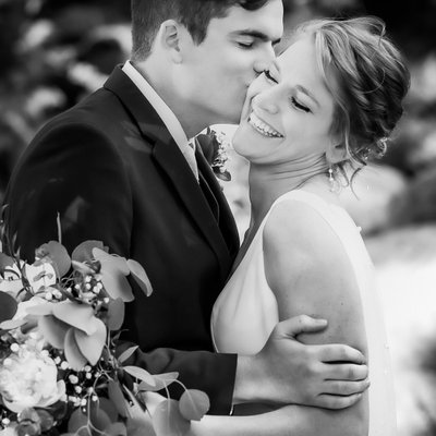 Journalistic Photo of Groom Kissing Bride on Cheek