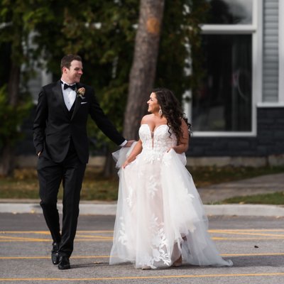 Groom in Tuxedo Helping Bride with Dress at Living Water