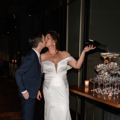 Bride Groom Kissing While Pouring Champagne Tower