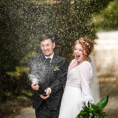 Bride Groom Popping Champagne on Country Road