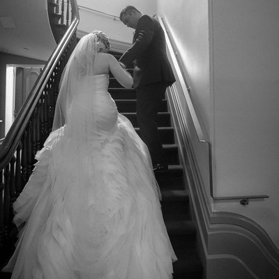 Groom Aids Bride Up Stairs at Brampton Wedding Venue