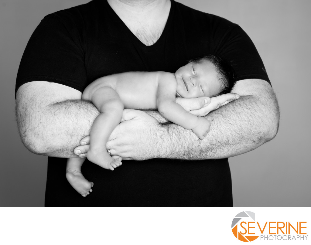 newborn pose with father boy black and white