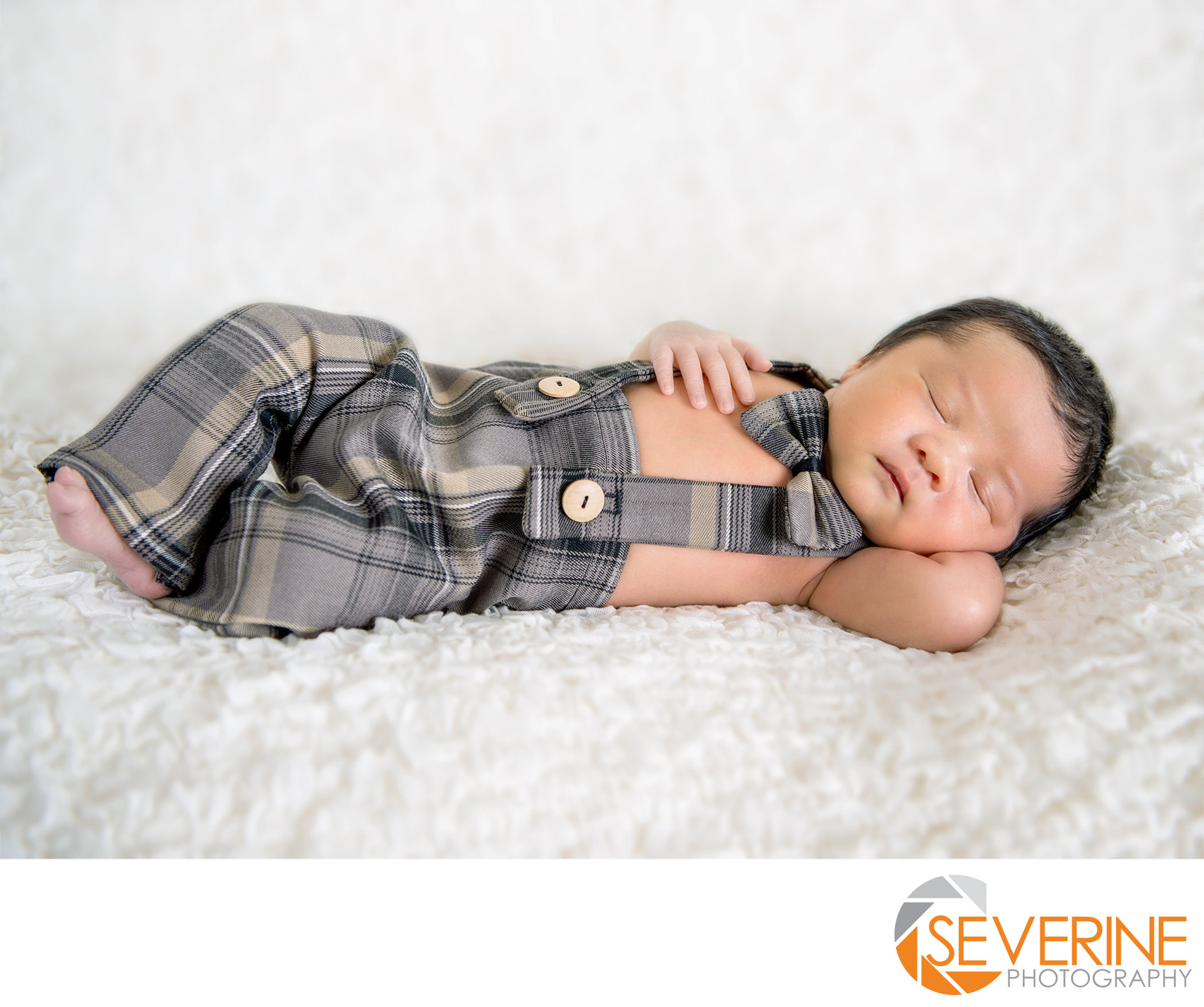 newborn boy with brown suit pose photos pictures Newborn Commercial