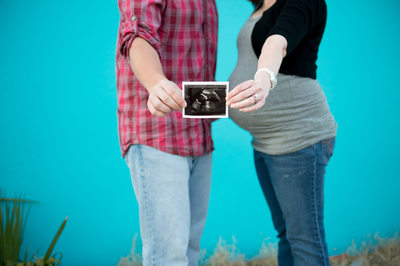 maternity photos posing example jeans blue wall