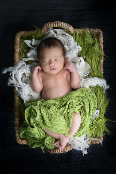 boy newborn with green blanket and natural basket
