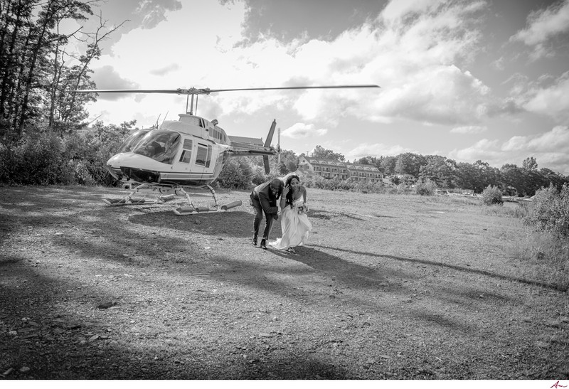 Bride and groom exit helicopter after wedding photos.