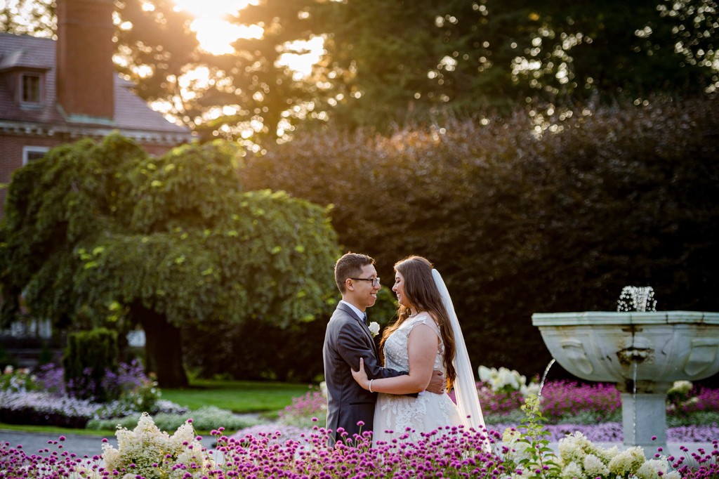 Newlyweds embrace by the fountain at Elm Bank weddings