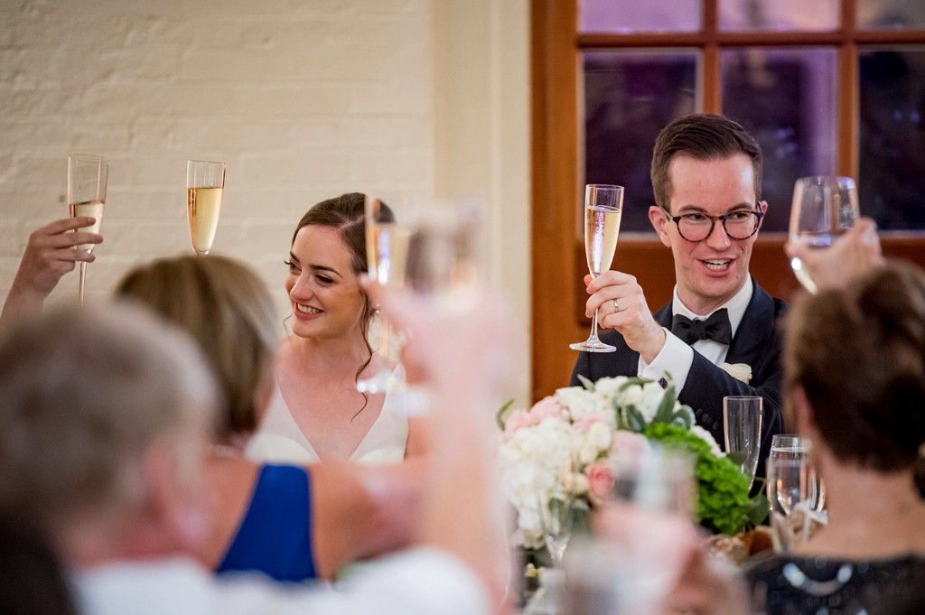 Bride and groom raising glasses at Elm Bank reception