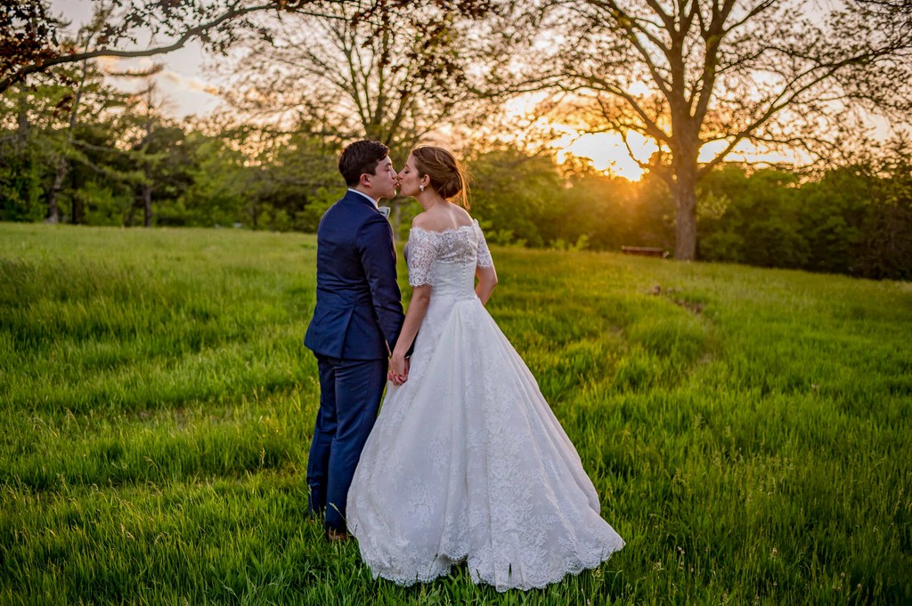 Bride and groom embracing in a golden field at Elm Bank wedding