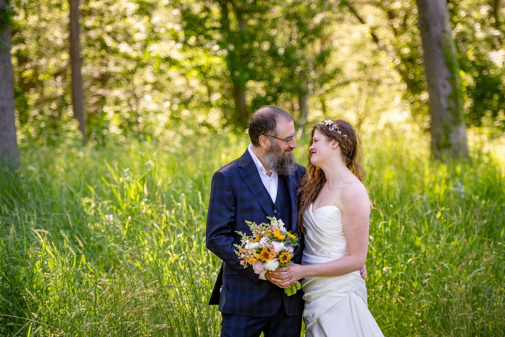 Bride and groom embracing in wildflower meadow at Long Hill