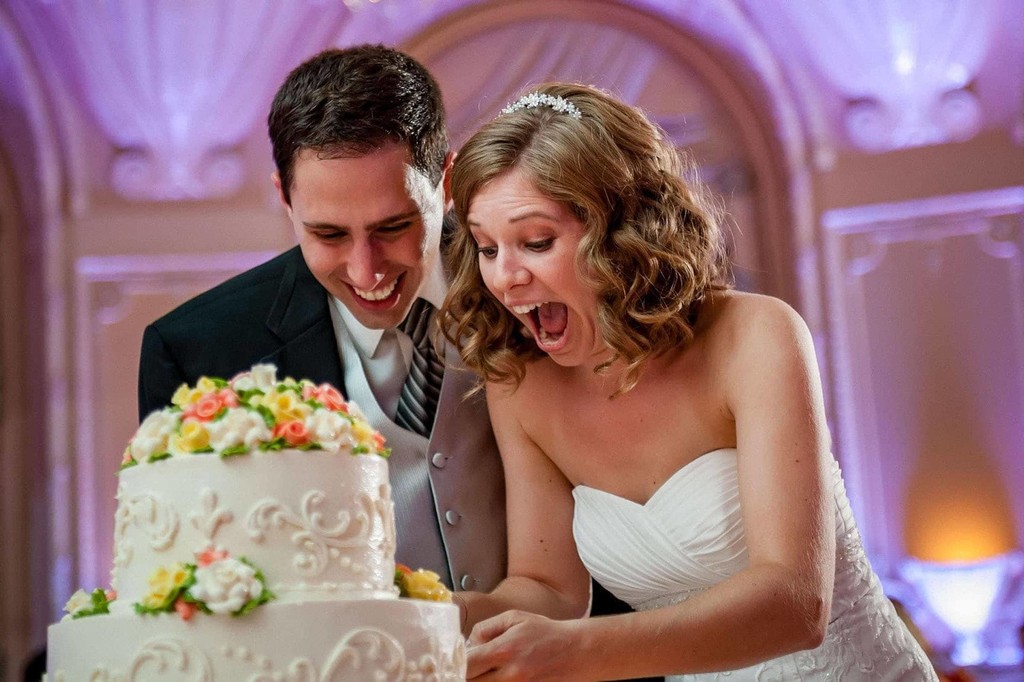 Joyful cake-cutting fun and a very expressive bride and groom