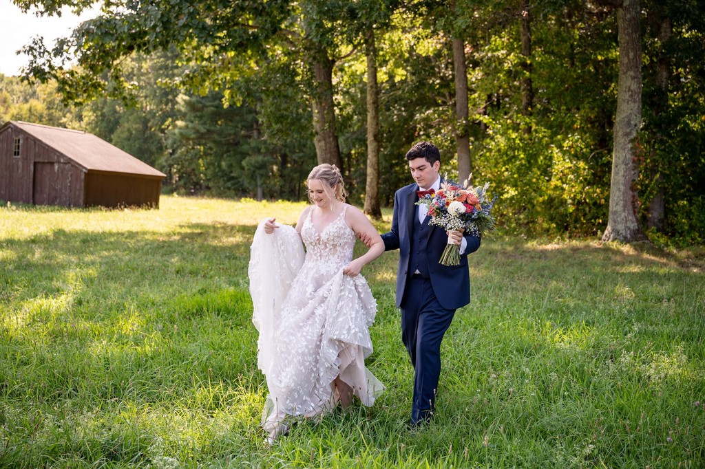 Just married stroll across the Fern Hill Barn fields
