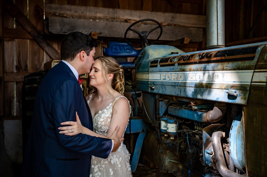 Rustic barn wedding portrait with tractor at Fern Hill Barn