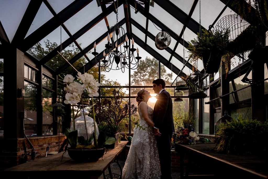 Bride and groom silhouette in greenhouse – Fern Hill Barn
