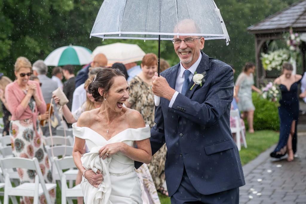 Rainy ceremony exit with clear umbrella at Fern Hill Barn