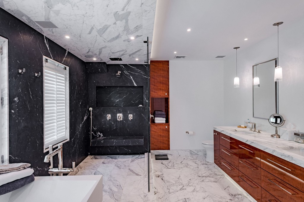 Contemporary bathroom with black tile and wood vanity