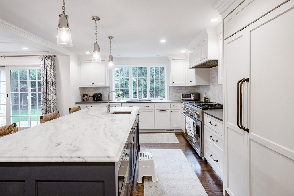 White kitchen with pendant lighting and marble countertops