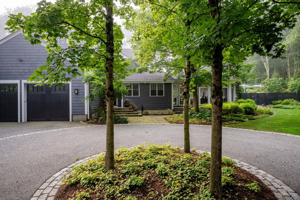 Suburban home exterior with driveway and mature trees