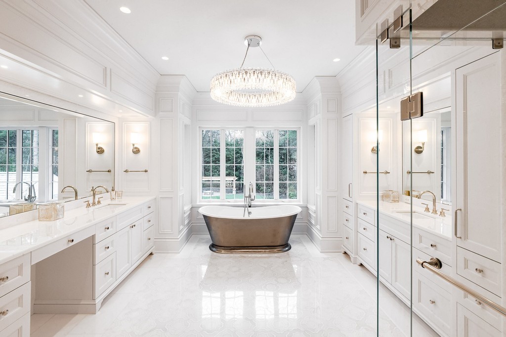 White marble bathroom with chandelier and freestanding tub
