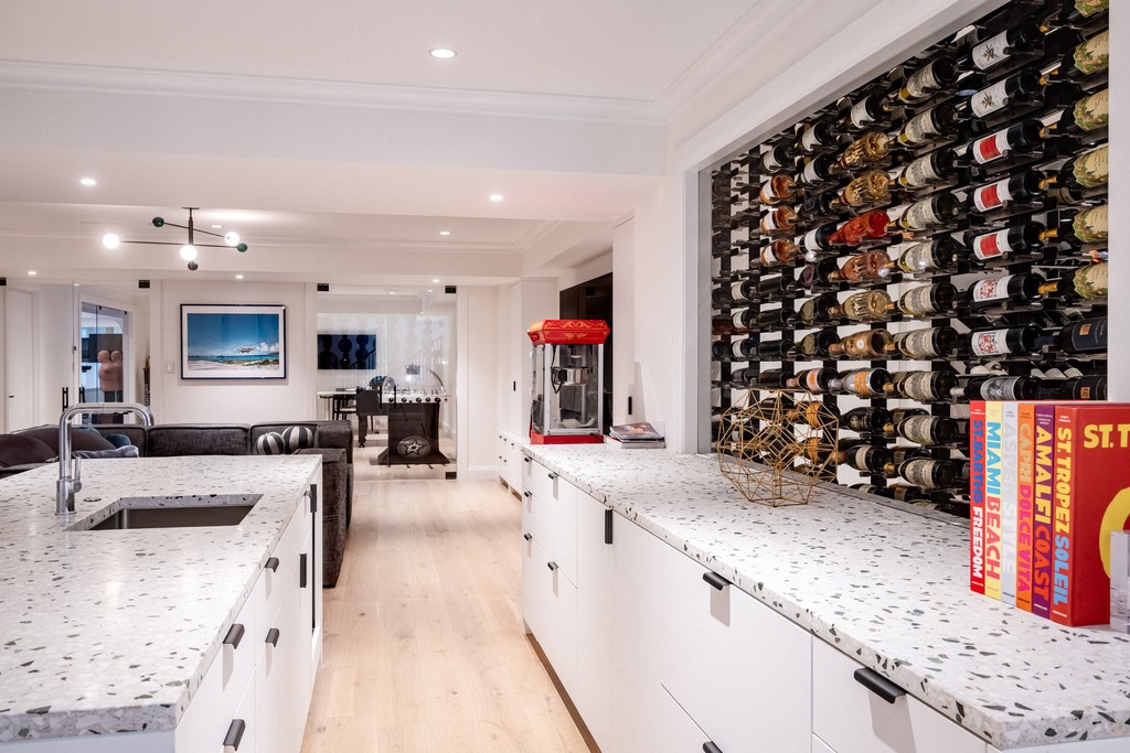 Basement kitchen with wine room wall and black hardware