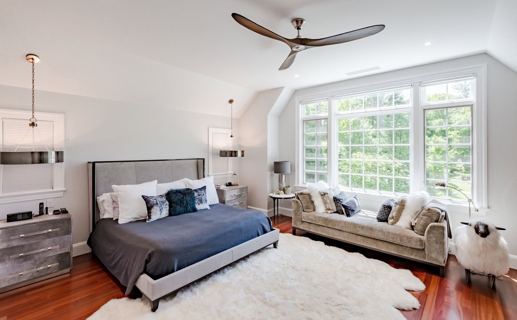 Light-filled bedroom with seating nook and tray ceiling