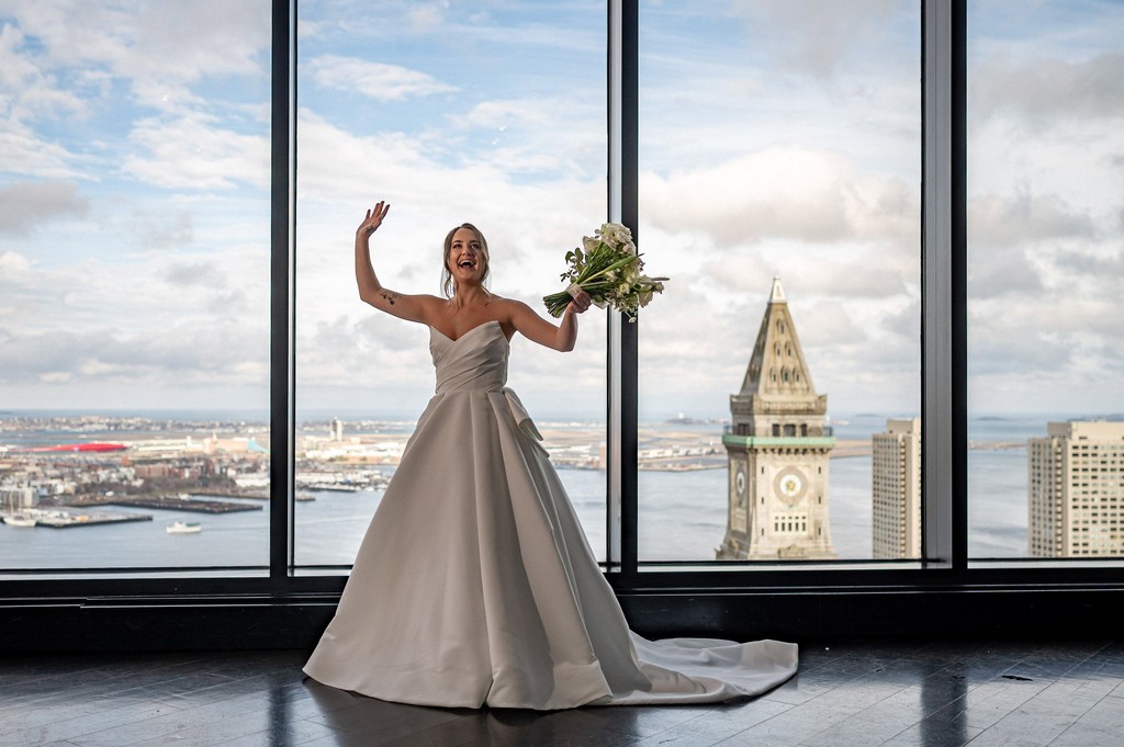Bride joking around in front of skyline view window