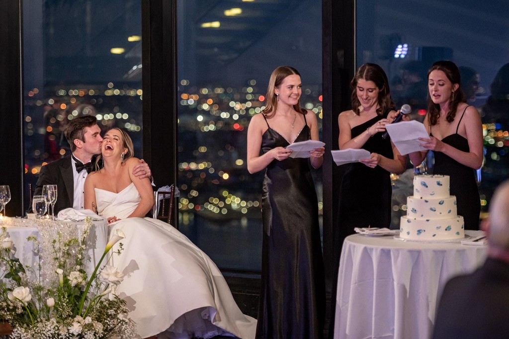 Bride and groom laughing at bridesmaids speeches
