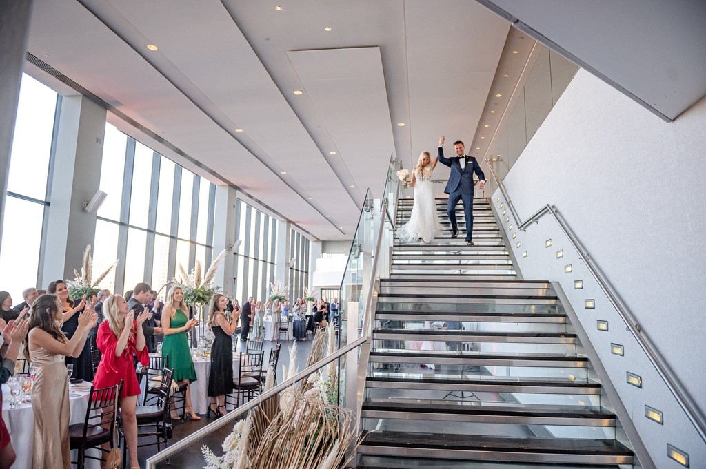 Bride and groom walking down Great Room staircase