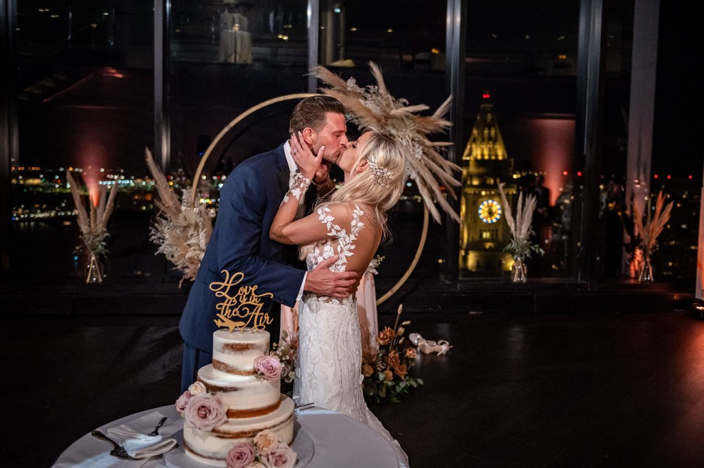 Cake cutting with nighttime city skyline view